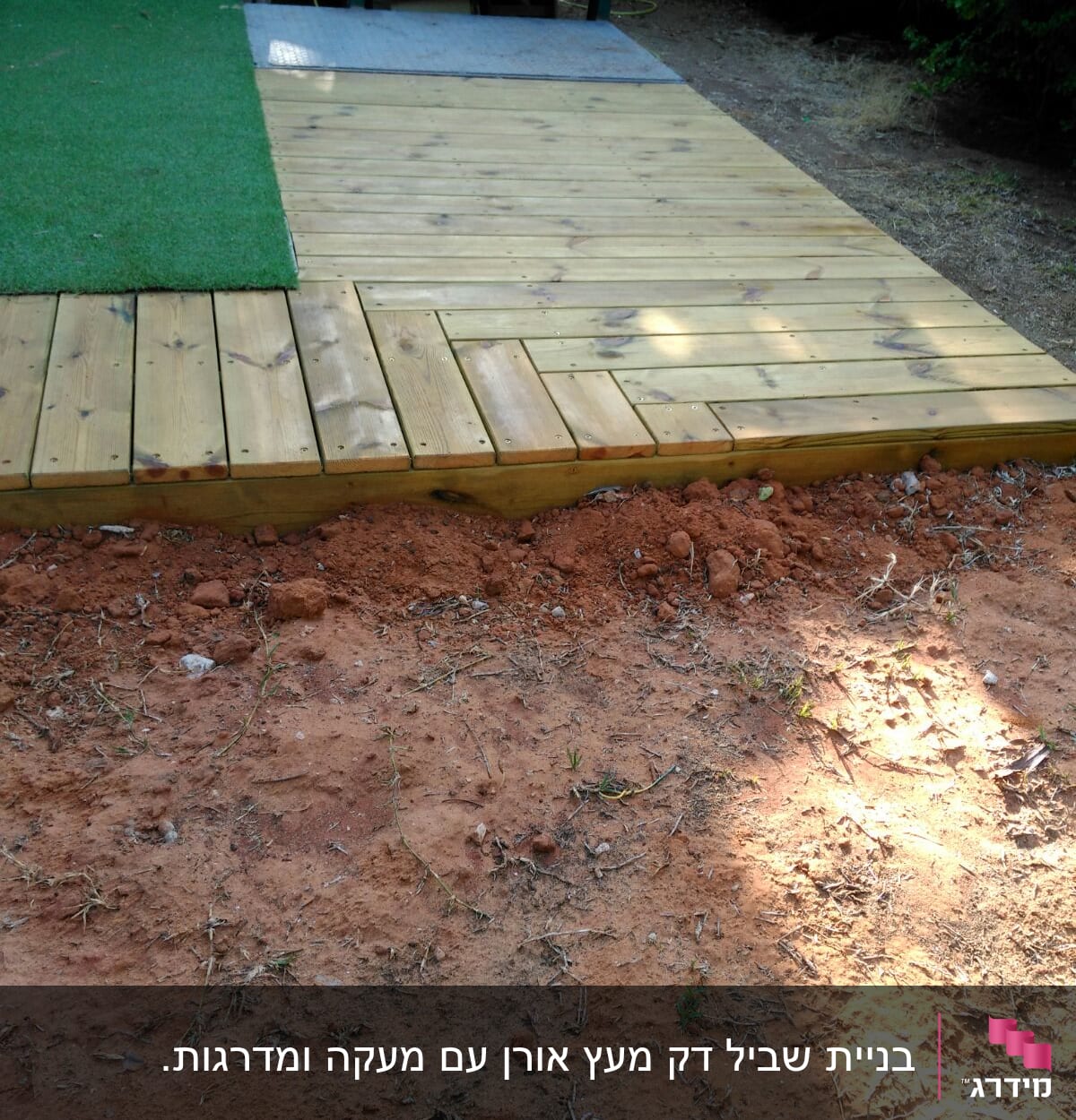 דק עץ חדש ליד דשא סינתטי ואדמה חשופה